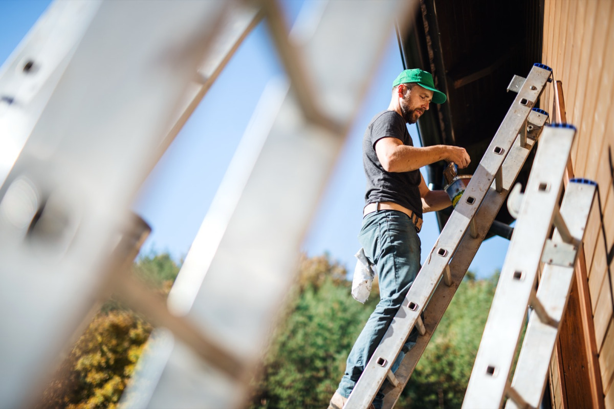 Schilder aan het werk op een woning in Friesland